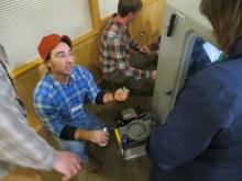 Station Specialist Jason Theis explains some of the “brains” of the Transportable Array station. (Photo by Beth Grassi)